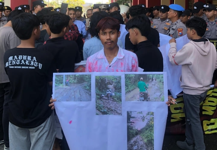 Massa aksi bawa poster berisi foto kondisi jalan yang rusak parah di Pulau Kangean.