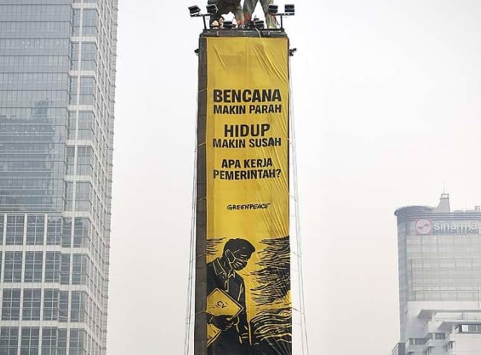 Spanduk raksasa yang dipasang aktivis Greenpeace Indonesia di atas Patung Selamat Datang Bundaran HI, Jakarta Pusat. [Foto: Greenpeace Indonesia]